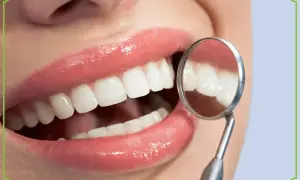 Błyszczące, białe zęby w odbiciu lusterka dentystycznego. Idealne dla osób stosujących białą dietę.