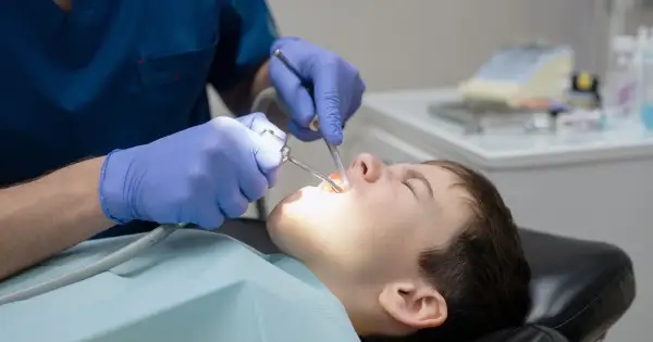 Chłopiec pod narkozą u dentysty. Sprawdź leczenie zębów pod narkozą cennik, by zapewnić komfort.